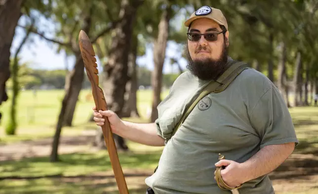 Michael Rice holds a Hawaiian war spear, Ihe, which his uncle made with koa wood 20 years ago, at Kapiolani Park on Saturday, June 22, 2024, in Honolulu, Hawaii. (AP Photo/Mengshin Lin)