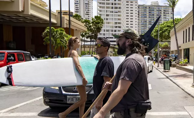 Andrew Roberts, director of the Hawaii Firearms Coalition, holds a halberd while walking down Kalakaua Avenue in Waikiki on Saturday, June 22, 2024, in Honolulu, Hawaii. (AP Photo/Mengshin Lin)