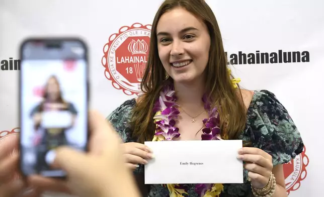 Lahainaluna High School 2024 graduate Emily Hegrenes poses with her scholarship announcement in the school's library Wednesday, July 31, 2024, in Lahaina, Hawaii. (AP Photo/Matthew Thayer)