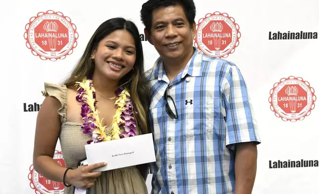 Lahainaluna High School 2024 graduate Keith Baniqued poses with father Johnny Baniqued during a scholarship presentation in the school's library Wednesday, July 31, 2024, in Lahaina, Hawaii. (AP Photo/Matthew Thayer)