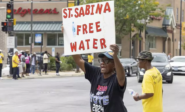 FILE - Volunteers from Saint Sabina Church distributed bottles of cold water to passing motorists at a busy South Side intersection in Chicago, Aug. 27, 2024. (AP Photo/Teresa Crawford, File)