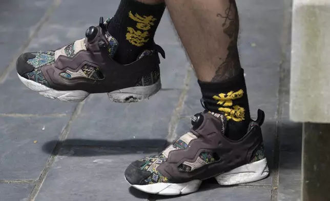 Joker Chan's socks embroidered with the words "Hong Kong" poses for photographs after an interview, in Hong Kong, on June 28, 2024. Five years after Hong Kong's massive anti-government protests erupted, the lives of many young people like Chan who were jailed or arrested during Beijing's political crackdown on the city's pro-democracy movement remain in limbo. (AP Photo/Billy H.C. Kwok)