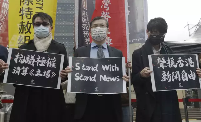 FILE - Protesters from Hong Kong in Taiwan and local supporters hold slogans reading "Protest Against Totalitarian Liquidation of Stand News" and " Support Press Freedom in Hong Kong" to protest outside of the Bank of China in Taipei, Taiwan, Dec. 30, 2021. (AP Photo/Chiang Ying-ying, File)