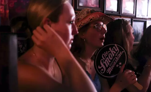 A group of people smile at Nashville’s Robert’s Western World honky tonk on Sunday, July 28, 2024, in Nashville, Tenn. (AP Photo/Luis Andres Henao)