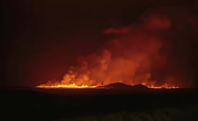 A new volcanic eruption is seen from the intersection between Reykjanesbraut, Iceland, and the road to Grindavik, Thursday, Aug. 22, 2024. (AP Photo/Marco di Marco)