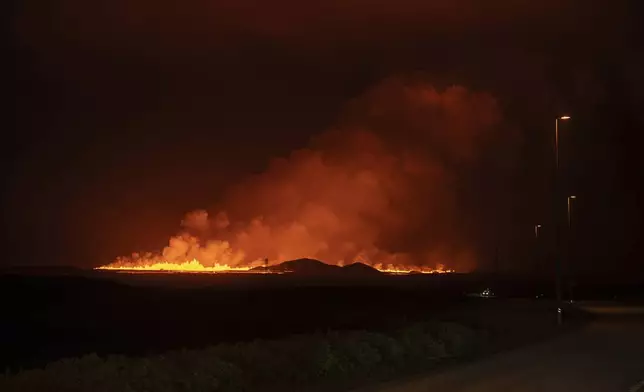 A new volcanic eruption is seen from the intersection between Reykjanesbraut, Iceland, and the road to Grindavik, Thursday, Aug. 22, 2024. (AP Photo/Marco di Marco)