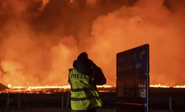 Photographers and journalists on location filming and reporting on the new fissure north of Grindavik, Iceland, Thursday, Aug. 22, 2024, (AP Photo/Marco di Marco)