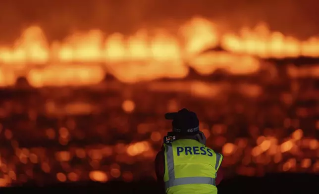 Photographers and journalists on location filming and reporting on the new fissure north of Grindavik, Iceland, Thursday, Aug. 22, 2024, (AP Photo/Marco di Marco)