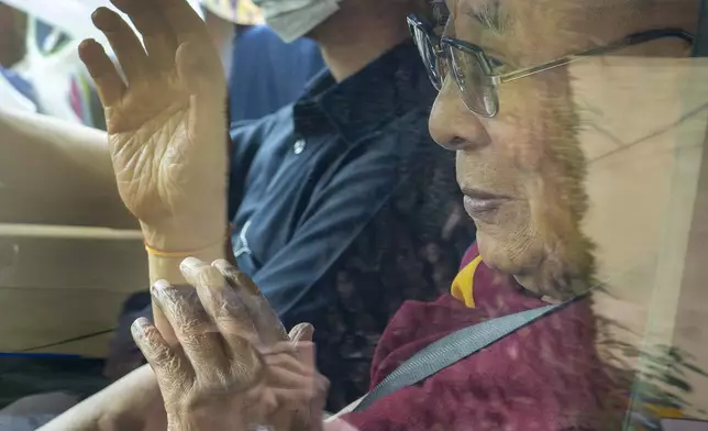 Tibetan spiritual leader the Dalai Lama greets a welcoming crowd from inside his car as he arrived in Dharamshala, India, Wednesday, Aug. 28, 2024. (AP Photo/Ashwini Bhatia)