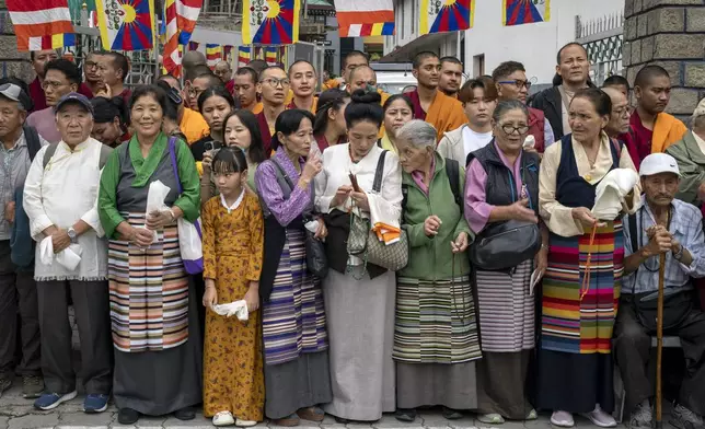 Exiled Tibetans wait with ceremonial scarves to welcome their spiritual leader the Dalai Lama before he arrived in Dharamshala, India, Wednesday, Aug. 28, 2024. (AP Photo/Ashwini Bhatia)