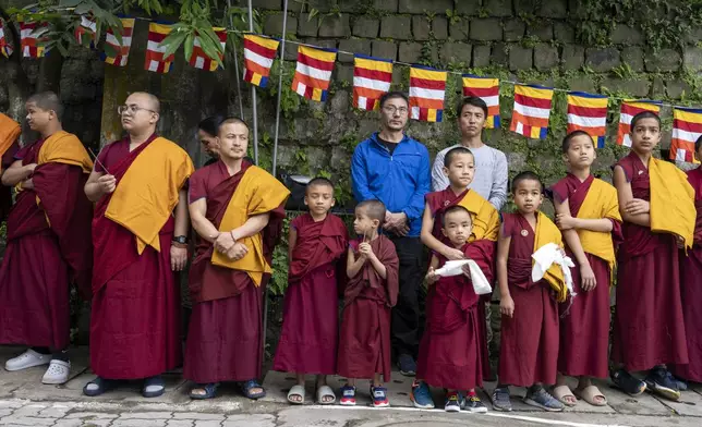 Novice Buddhist monks wait with ceremonial scarves to welcome Tibetan spiritual leader the Dalai Lama before he arrived in Dharamshala, India, Wednesday, Aug. 28, 2024. (AP Photo/Ashwini Bhatia)