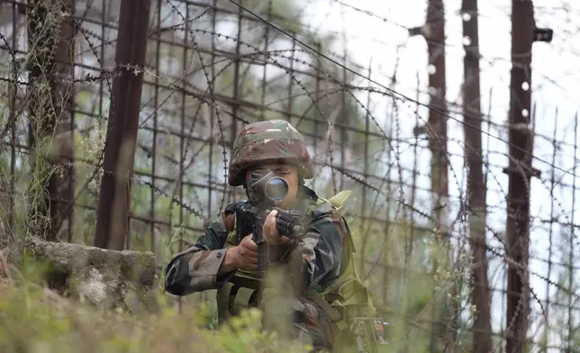 An Indian army soldier takes position during a drill along the highly militarized Line of Control that divides Kashmir region between India and Pakistan, in Nowshera sector about 127 kilometers (79 miles) from Jammu, India, Monday, Aug.12, 2024. (AP Photo/Channi Anand)