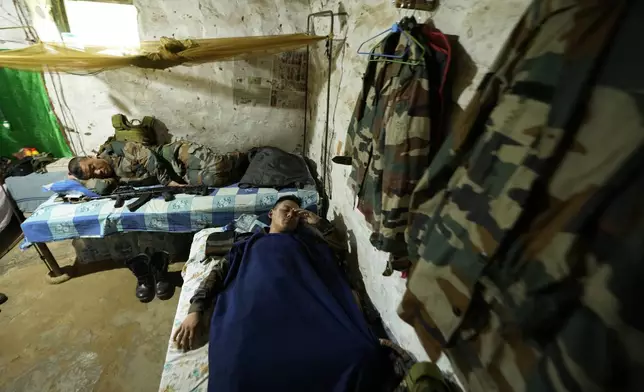 Indian army soldiers rest in full combat gear in their bunker along the highly militarized Line of Control that divides Kashmir region between India and Pakistan, in Nowshera sector about 127 kilometers (79 miles) from Jammu, India, Monday, Aug.12, 2024. (AP Photo/Channi Anand)