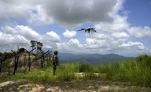 An Indian army soldier watches a surveillance drone during a mock drill along the highly militarized Line of Control that divides Kashmir region between India and Pakistan, in Nowshera sector about 127 kilometers (79 miles) from Jammu, India, Monday, Aug.12, 2024. (AP Photo/Channi Anand)