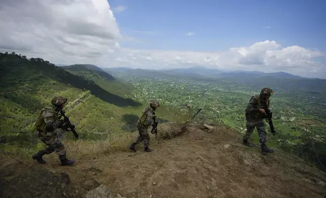 Indian army soldiers participate in a drill along the highly militarized Line of Control that divides Kashmir region between India and Pakistan, in Nowshera sector about 127 kilometers (79 miles) from Jammu, India, Monday, Aug.12, 2024. (AP Photo/Channi Anand)