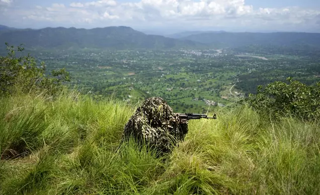 An Indian army soldier takes position during a mock drill along the highly militarized Line of Control that divides Kashmir region between India and Pakistan, in Nowshera sector about 127 kilometers (79 miles) from Jammu, India, Monday, Aug.12, 2024. (AP Photo/Channi Anand)