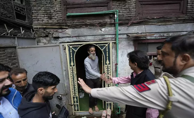 Ashok Bhat, right, a candidate of the Bharatiya Janata Party (BJP) shakes hand with a voter while campaigning door-to-door ahead of the Jammu and Kashmir state assembly elections in Srinagar, Indian controlled Kashmir, Thursday, Aug. 29, 2024.(AP Photo/Mukhtar Khan)