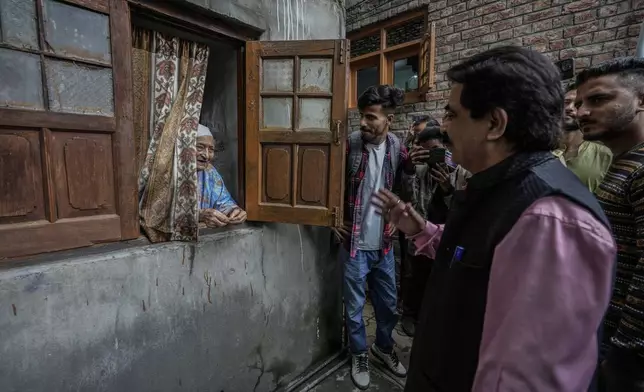 Ashok Bhat, right, a candidate of the Bharatiya Janata Party (BJP) talks to an elderly Kashmiri woman, while campaigning door-to-door ahead of the Jammu and Kashmir state assembly elections, in Srinagar, Indian controlled Kashmir, Thursday, Aug. 29, 2024. (AP Photo/Mukhtar Khan)