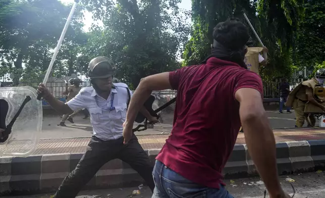 A policeman hits a protester against the rape and murder of a resident doctor at a government hospital earlier this month, in Kolkata, India, Tuesday, Aug. 27, 2024. (AP Photo/Bikas Das)