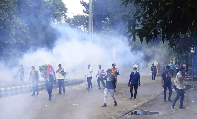 Police fire tear gas shells to disperse people protesting against the rape and murder of a resident doctor at a government hospital earlier this month, in Kolkata, India, Tuesday, Aug. 27, 2024. (AP Photo/Bikas Das)