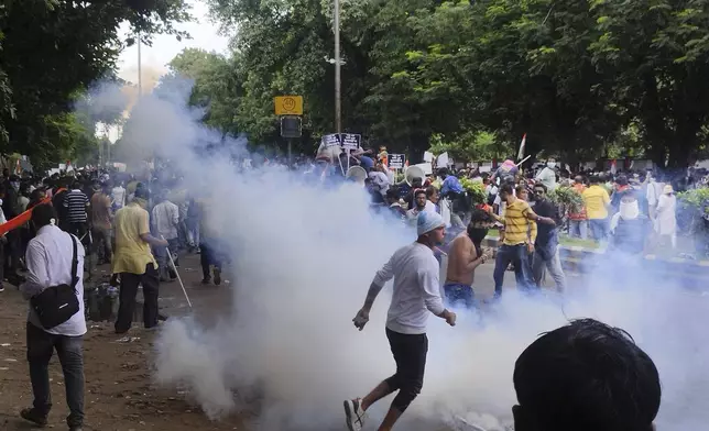 Police fire tear gas shells to disperse people protesting against the rape and murder of a resident doctor at a government hospital earlier this month, in Kolkata, India, Tuesday, Aug. 27, 2024. (AP Photo/Bikas Das)