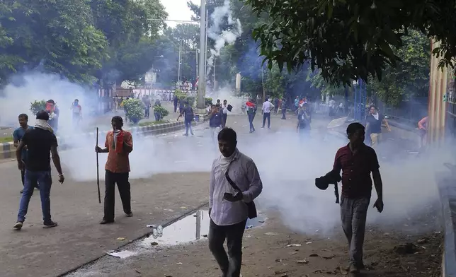 Police fire tear gas shells to disperse people protesting against the rape and murder of a resident doctor at a government hospital earlier this month, in Kolkata, India, Tuesday, Aug. 27, 2024. (AP Photo/Bikas Das)