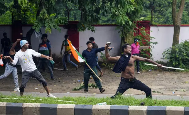 Protesters throw stones towards police while protesting against the rape and murder of a resident doctor at a government hospital earlier this month, in Kolkata, India, Tuesday, Aug. 27, 2024. (AP Photo/Bikas Das)