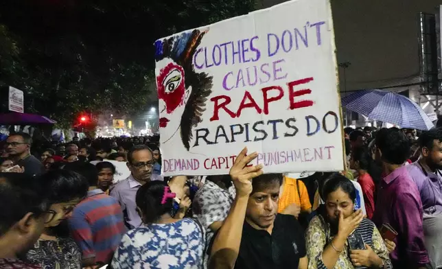 Students join other protesters in a midnight rally protesting against the murder of a 31 year old post-graduate trainee demanding proper investigation in Kolkata, India, Wednesday, Aug. 14, 2024. (AP Photo/Bikas Das)