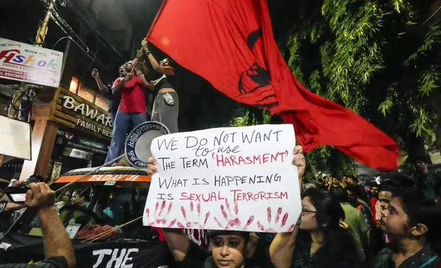 Students join other protesters in a midnight rally protesting against the murder of a 31 year old post-graduate trainee demanding proper investigation in Kolkata, India, Wednesday, Aug. 14, 2024. (AP Photo/Bikas Das)