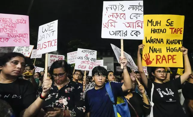 Students join other protesters in a midnight rally protesting against the murder of a 31 year old post-graduate trainee demanding proper investigation in Kolkata, India, Wednesday, Aug. 14, 2024. (AP Photo/Bikas Das)