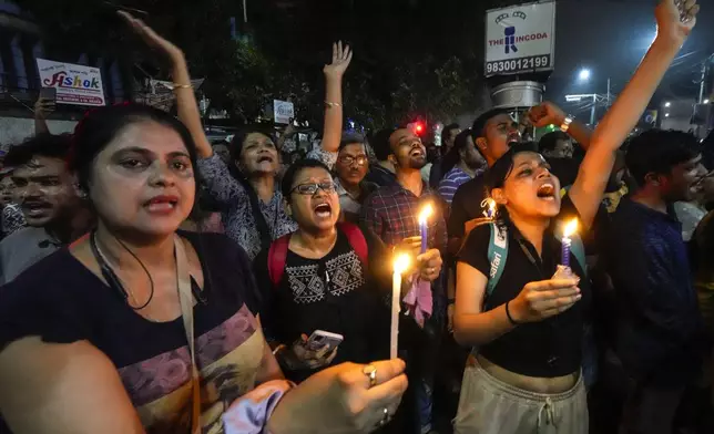 Students join other protesters in a midnight rally protesting against the murder of a 31 year old post-graduate trainee demanding proper investigation in Kolkata, India, Wednesday, Aug. 14, 2024. (AP Photo/Bikas Das)