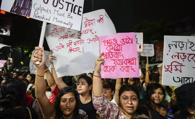 Students join other protesters in a midnight rally protesting against the murder of a 31 year old post-graduate trainee demanding proper investigation in Kolkata, India, Wednesday, Aug. 14, 2024. (AP Photo/Bikas Das)