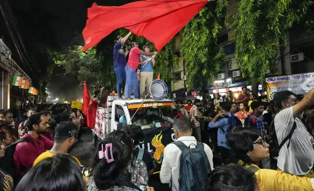 Protesters join in a midnight rally protesting against the murder of a 31 year old post-graduate trainee demanding proper investigation in Kolkata, India, Wednesday, Aug. 14, 2024. (AP Photo/Bikas Das)