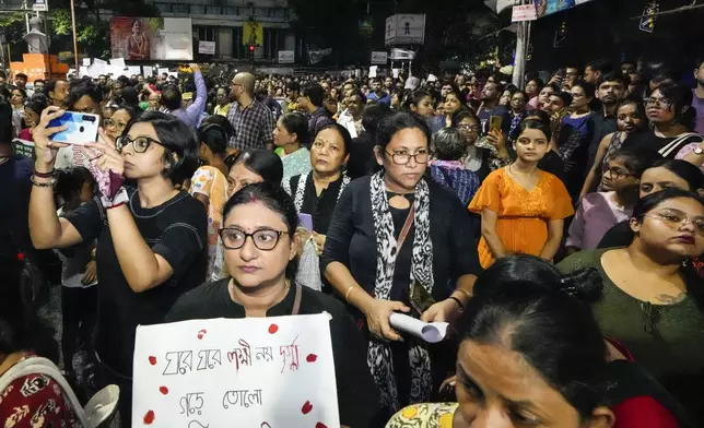 Students join other protesters in a midnight rally protesting against the murder of a 31 year old post-graduate trainee demanding proper investigation in Kolkata, India, Wednesday, Aug. 14, 2024. (AP Photo/Bikas Das)