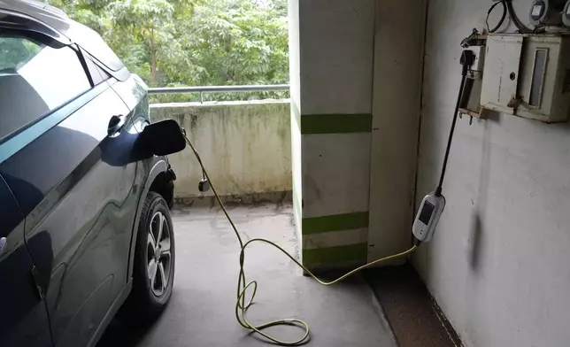 A car gets charged at the Electric Vehicle charging station at a residential building parking area in Mumbai, India, July 23, 2024. (AP Photo/Rajanish Kakade)