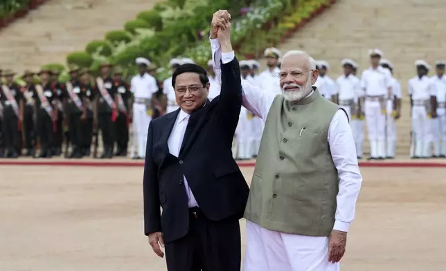 Indian Prime Minister Narendra Modi, right, and his Vietnamese counterpart Pham Minh Chinh join hands during a ceremonial reception at the Rashtrapati Bhavan in New Delhi, India, Thursday, Aug. 1, 2024. (AP Photo)