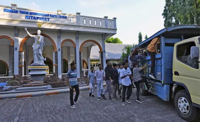 Seminarians of Ritapiret Major Seminary climb onto a the truck that will take them to their classes at Ledalero Institute of Philosophy and Creative Technology in Maumere, East NusaTenggara province, Indonesia, Friday, Aug. 23, 2024. (AP Photo/Tatan Syuflana)