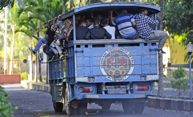 Seminarians climb onto a the truck that will take them to their classes at Ritapiret Major Seminary in Maumere, East NusaTenggara province, Indonesia, Friday, Aug. 23, 2024. (AP Photo/Tatan Syuflana)