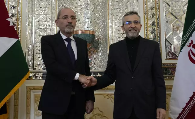 Jordan's Foreign Minister Ayman Safadi, left, and Iran's acting Foreign Minister Ali Bagheri Kani, shake hands before the start of their meeting in Tehran, Iran, Sunday, Aug. 4, 2024. (AP Photo/Vahid Salemi)