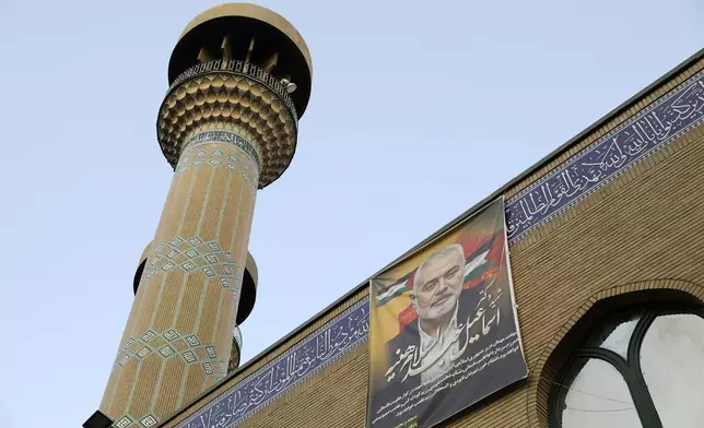 A poster of the late Hamas leader Ismail Haniyeh, who was killed in an assassination last week, hangs on a mosque building in downtown Tehran, Iran, Monday, Aug. 5, 2024. Iran has vowed to respond with "power and decisiveness" to the targeted killing of Hamas' top political leader, which it blamed on Israel. (AP Photo/Vahid Salemi)