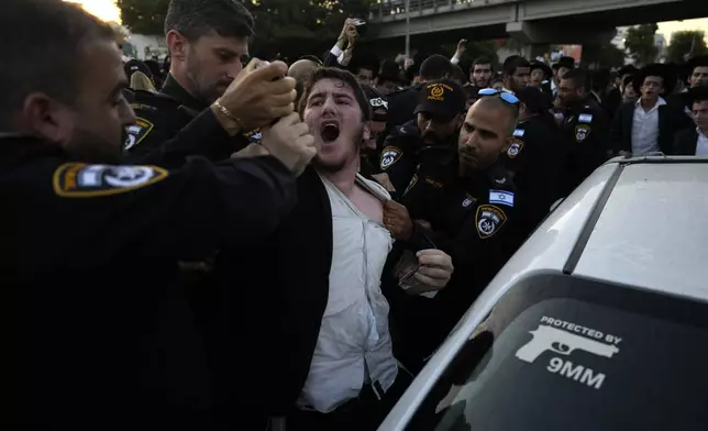 Israeli police detain an ultra-Orthodox Jewish youth protesting against military recruitment in Bnei Brak, near Tel Aviv, Israel, Thursday, Aug. 1, 2024. (AP Photo/Ariel Schalit)