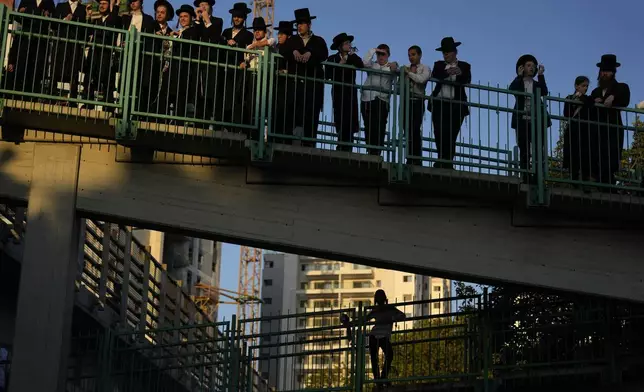 Ultra-Orthodox Jews gather on a bridge as others block a road to protest against military recruitment, in Bnei Brak, near Tel Aviv, Israel, Thursday, Aug. 1, 2024. (AP Photo/Ariel Schalit)