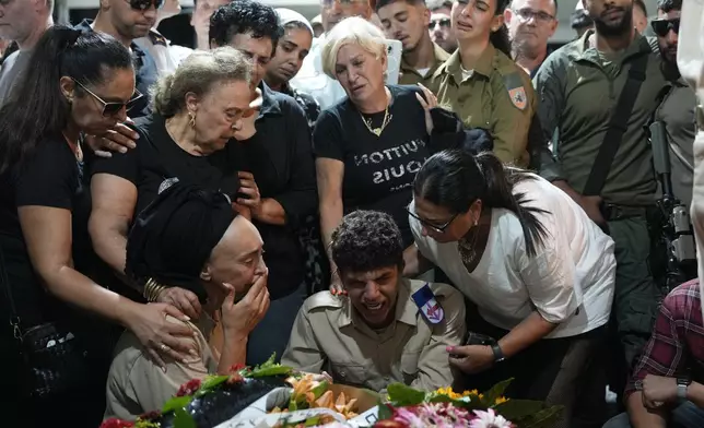 Iris Shitrit, seated left, the mother and relatives of Petty Officer 1st Class David Moshe Ben Shitrit, who was killed on a Hezbollah attack, mourn during his funeral at the Mount Herzl military cemetery in Jerusalem, Sunday, Aug. 25, 2024. (AP Photo/Ohad Zwigenberg)