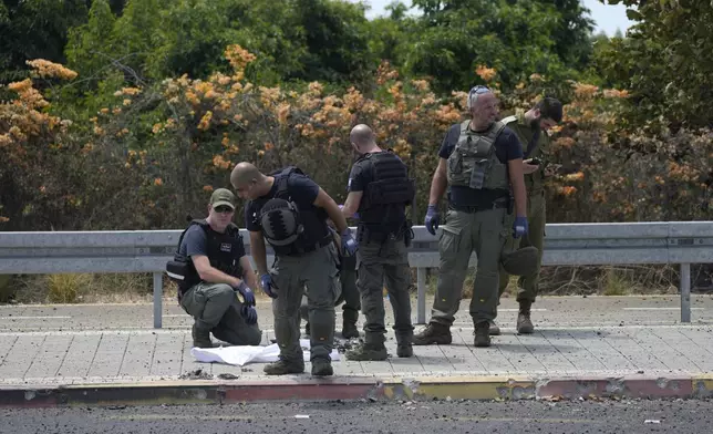 Israeli Police work at the site of a drone strike in Nahariya, Israel, Tuesday, Aug. 6, 2024. (AP Photo/Ohad Zwigenberg)