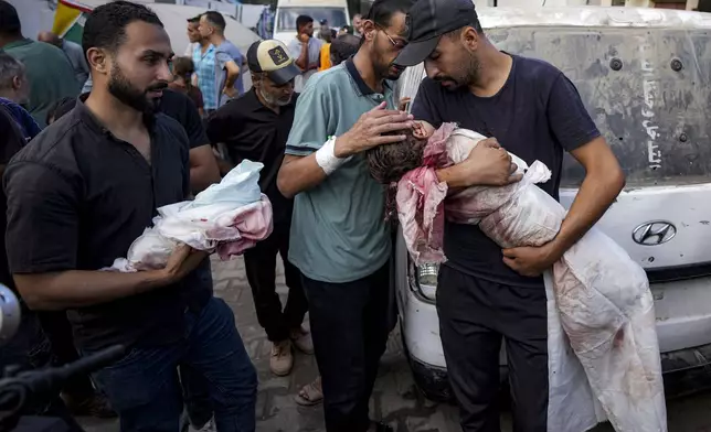 Relatives mourn children killed in the Israeli bombardment of the Gaza Strip at a hospital in Deir al-Balah, Friday, Aug.30, 2024. (AP Photo/Abdel Kareem Hana)