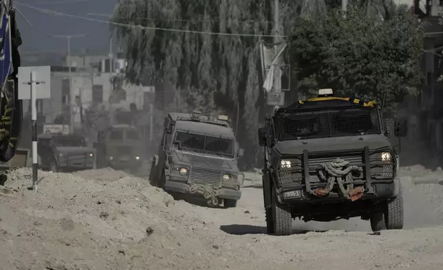 Israeli armoured vehicles move on a street during a military operation in the West Bank refugee camp of Nur Shams, Tulkarem, Thursday, Aug. 29, 2024. (AP Photo/Majdi Mohammed)