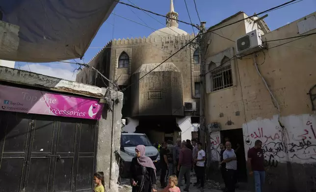 Palestinians stand outside a damaged mosque following an Israeli military operation in the West Bank refugee camp of Al-Faraa, Thursday, Aug. 29, 2024. (AP Photo/Nasser Nasser)