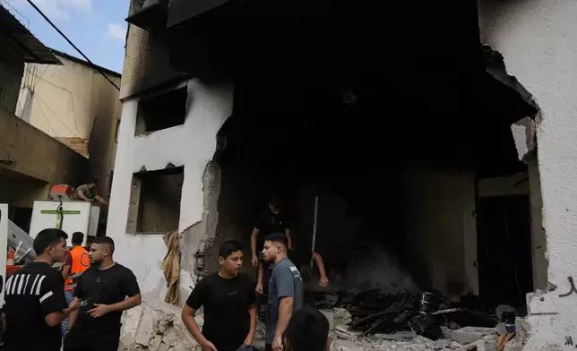 Palestinians stand outside a heavily damaged mosque following an Israeli military operation in the West Bank refugee camp of Al-Faraa, Thursday, Aug. 29, 2024. (AP Photo/Nasser Nasser)