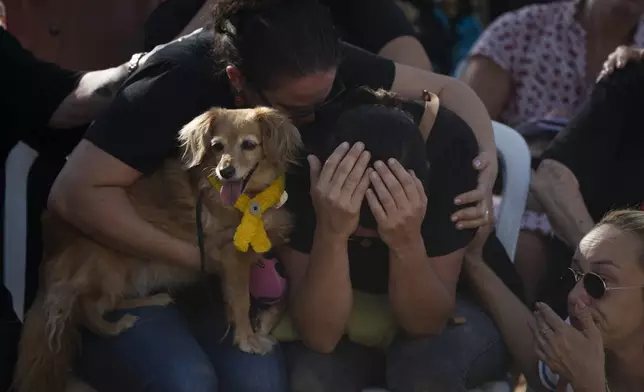 Rimon Buchshtab, center, mourns during the funeral of her husband Yagev Buchshtab at a cemetery of the kibbutz Nirim, southern Israel, Wednesday, Aug. 21, 2024. Buchshtab's body was one the six bodies of hostages, taken in Hamas' Oct. 7 attack, recovered by Israel's military during an operation in the Gaza Strip. (AP Photo/Leo Correa)