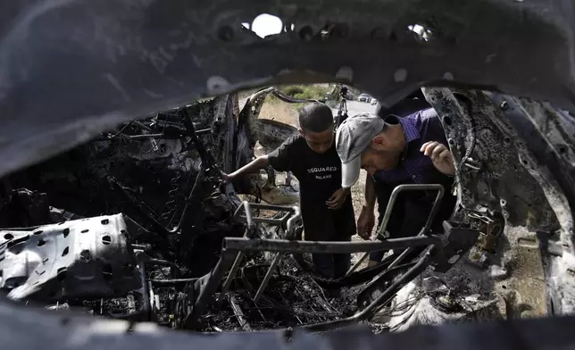 Palestinians inspect a car destroyed in a drone strike Zeita village, north of the West Bank city of Tulkarem, Saturday, Aug. 3, 2024. The Israeli military says it struck five suspected terrorists in a vehicle on their way to carry out an attack. (AP Photo/Majdi Mohammed)